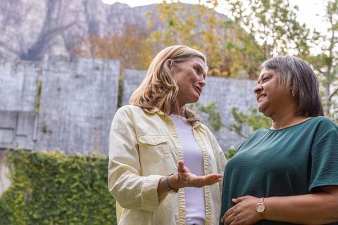 Middle-aged female friends engaged in outdoor conversation