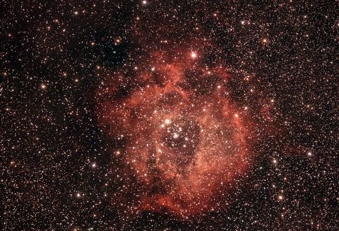 Spectacular red nebula illuminated by universe starry sky