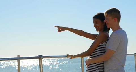 Joyful Biracial Couple Enjoying Scenic Ocean View Leisure Time