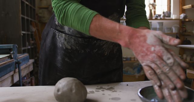 Mid section of male potter wiping his hands on apron at pottery studio - Download Free Stock Photos Pikwizard.com