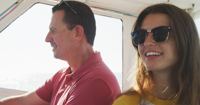 This depicts father and daughter smiling while enjoying a boat trip. Perfect for use in advertisements, articles about family vacations, outdoor activities, and parental bonding. Highlight the joy and relaxation of spending time with loved ones.