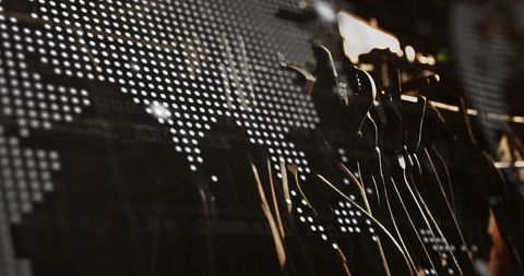 Backlit silhouetted mannequins lined on metal rack with led world map and glass reflections