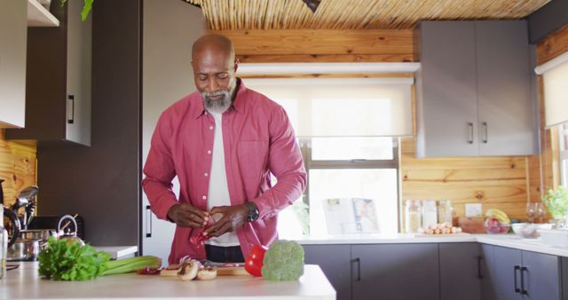 Middle-aged man cooking in modern kitchen, preparing vegetables - Download Free Stock Images Pikwizard.com