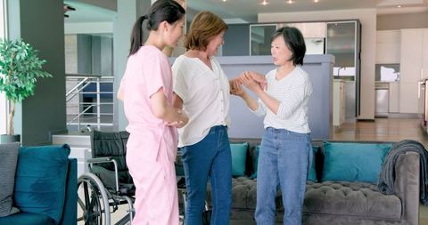Senior Women Sharing Moment with Nurse in Living Room