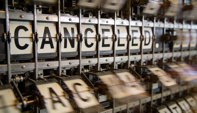 Spinning split-flap display showing cancelled on vintage mechanical board, motion blur