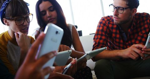 Young adults engaging with smartphones in casual environment