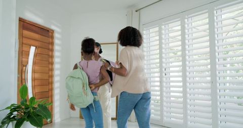Parent guiding children preparing for school in bright modern entryway with checklist