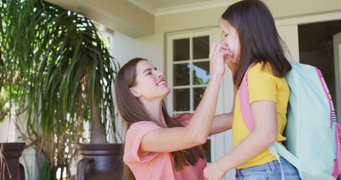 Mother Helps Daughter with Mask Before Leaving Home