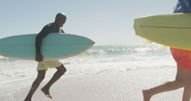 People running with surfboards on sandy beach - Download Free Stock Images Pikwizard.com