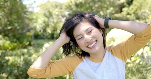 Joyful Woman Relaxing Outdoors in Nature with Sunny Smile