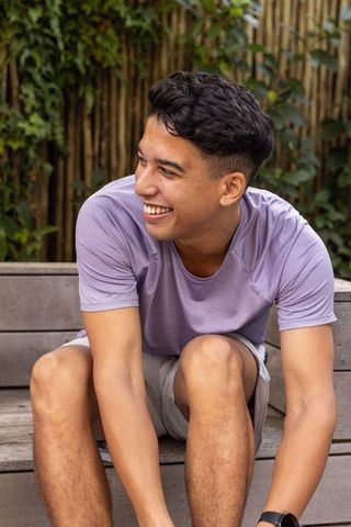 Young Man Relaxing Outdoors Wearing Sportswear Smiling