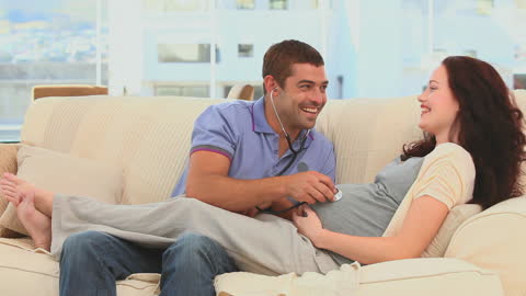 Expectant Father Listening to Baby With Stethoscope