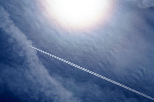 Airplane High Up With Contrail in Clear Sky Under Sun - Download Free Stock Photos Pikwizard.com