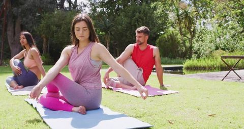 Group Practicing Yoga Outdoors With Tranquil Garden Backdrop