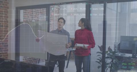 Diverse business team analyzing data and blueprints in office