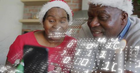 Senior black couple wearing santa hats using tablet with christmas digital overlay
