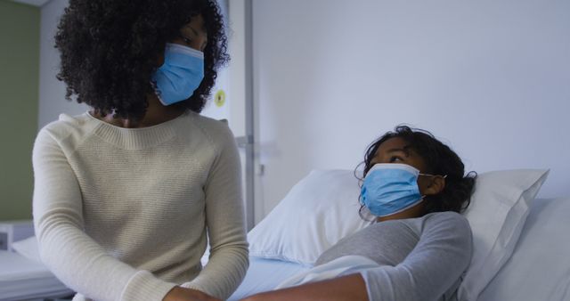 Mother Comforting Child in Hospital Bed Both Wearing Masks - Download Free Stock Images Pikwizard.com