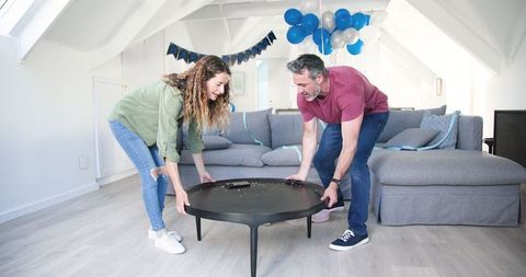 Couple tidying home after festive birthday celebration