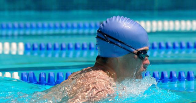 Man Swimming in Pool Wearing Blue Swim Cap and Goggles - Download Free Stock Photos Pikwizard.com