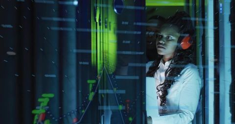 Woman Monitoring Servers in Datacenter with Laptop and Futuristic Data Overlays