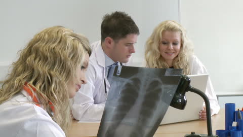 Medical Team Discussing X-rays and Strategies in Hospital Meeting