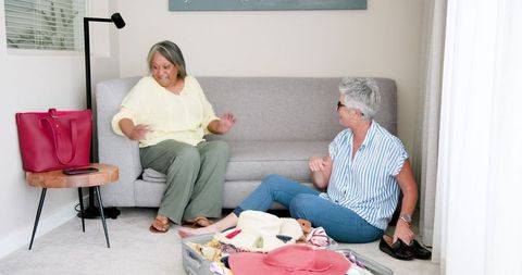 Happy Senior Lesbian Couple Packing for Vacation at Home