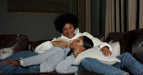 Cozy Diverse Couple Relaxing on Leather Sofa in Living Room