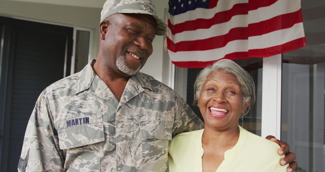 Image of happy african american senior soldier embracing wife and looking at camera. Family, american patriotism, freedom and spending time together concept.