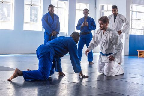 Martial arts students practicing grappling techniques in dojo