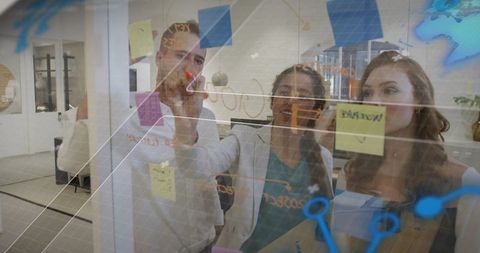 Creative team brainstorming on glass wall with sticky notes and network diagram overlay