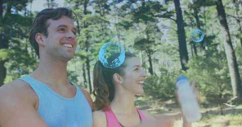 Couple Hydrating in Forest with Bubbles Enhancing Fitness Fun