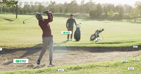Golfer Swinging in Bunker Focused on Technique with Observer Nearby