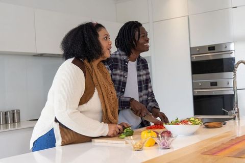 African American Couple Preparing Fresh Salad in Modern Minimalist Kitchen