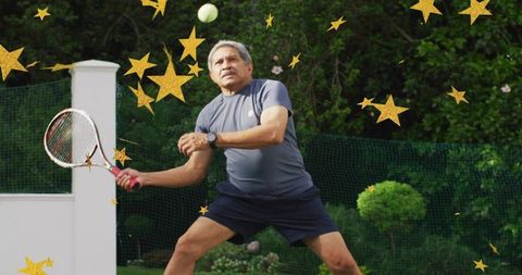 Senior man executing backhand on home lawn tennis court with gold star overlay celebration
