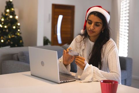 Woman Shopping Online on Laptop for Christmas With Credit Card