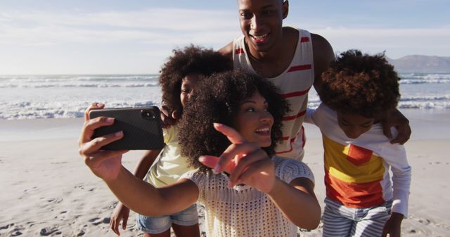 African american parents and their children taking a selfie with smartphone on the beach. family outdoor leisure time by the sea.