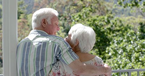 Senior Couple Embracing on Sunny Balcony Outdoors - Download Free Stock Images Pikwizard.com