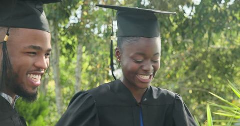 Happy african american graduates celebrating success outdoors