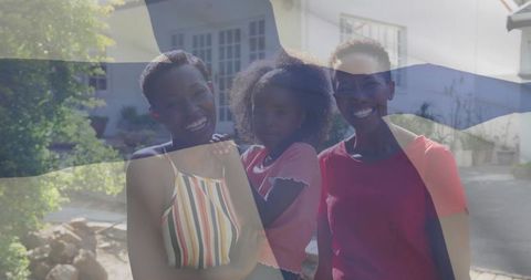 Smiling Mother and Daughters Posing Outside Suburban Home