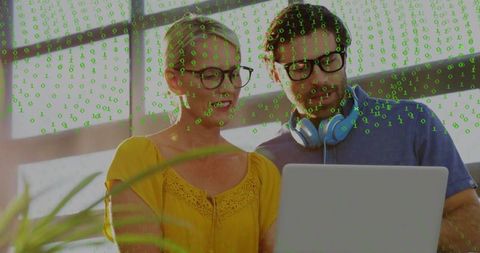 Colleagues reviewing laptop with binary code overlay for data security collaboration
