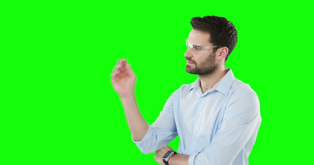 Young Man in Glasses Touching Virtual Interface on Green Screen - Download Free Stock Images Pikwizard.com