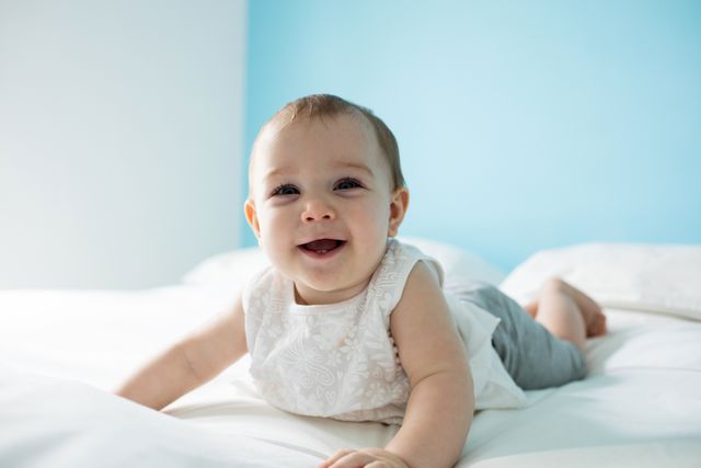 Cute smiling baby girl on bed - Download Free Stock Photos Pikwizard.com