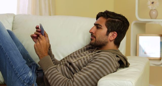 Man Relaxing on Sofa and Using Smartphone in Casual Setting - Download Free Stock Images Pikwizard.com