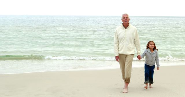 Grandfather and granddaughter walking together on the beach  - Download Free Stock Photos Pikwizard.com