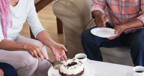 Seniors Sharing Cake and Conversation in Cozy Living Room