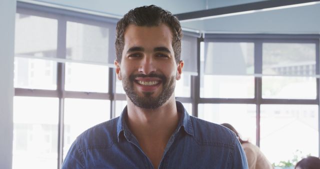 Smiling Man in Denim Shirt Standing in Office Environment - Download Free Stock Images Pikwizard.com