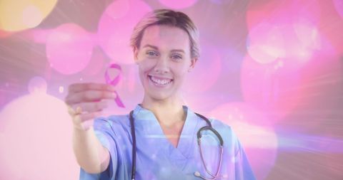 Smiling doctor holding pink ribbon symbolizing breast cancer awareness