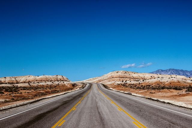Lonely Desert Highway Stretching into Blue Sky - Download Free Stock Photos Pikwizard.com