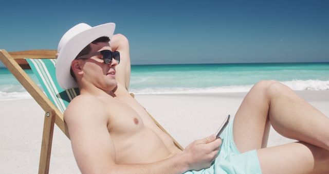 Man Relaxing on Beach Lounger with Smartphone in Hand - Download Free Stock Images Pikwizard.com