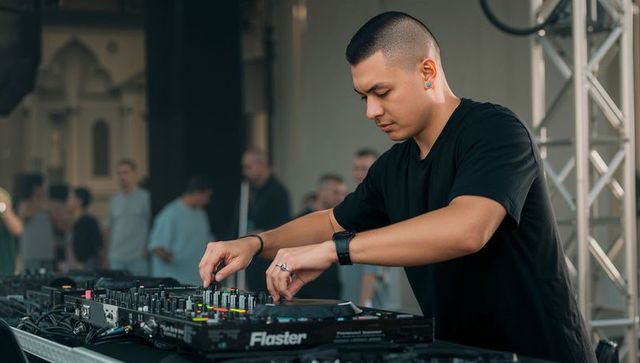 Mixing dj adjusting flaster console during live set on stage performing electronic music
